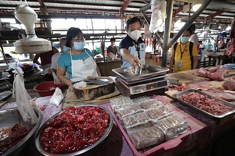 MONITORING PRICES. In this file photo, personnel from the City Government of San Fernando and DTI check a vendor's weighing scale while monitoring prices of basic goods. (Contributed photo)