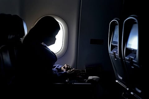 In this Wednesday, Feb. 3, 2021, file photo, a passenger wears a face mask she travels on a flight from Hartsfield-Jackson International Airport in Atlanta. In May 2021, the Centers for Disease Control and Prevention said people who are fully vaccinated no longer need to wear a mask indoors or outdoors and can stop social distancing in most places. But the CDC says everyone _ vaccinated or unvaccinated _ should continue to wear a mask in certain places. Masks are still required on public transportation _ buses, trains and planes _ and in other settings like hospitals, prisons and homeless shelters. (AP file photo)