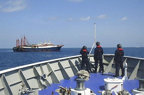 MANILA. In this April 27, 2021, photo provided by the Philippine Coast Guard, its personnel patrol beside ships said to be Chinese militia vessels at Sabina Shoal in the South China Sea. (AP)
