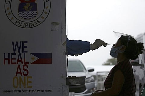 MANILA. A health worker performs a Covid-19 swab test on a patient during a stricter lockdown at a free Covid-19 drive-thru testing facility in Manila on August 6, 2021. (AP)