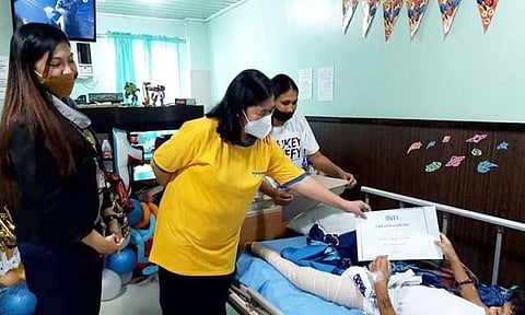 SCHOLARSHIP: Gitunol sa taga STI Ormoc ang scholarship title kang Bengielim Donayre, ang 11 anyos nga survivor ug nawad-an og ginikanan ug igsuon sa nahitabong landslide sa Baybay City, Leyte. / tampo ni Vincent Paulo Cortes