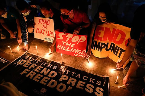 MANILA. Activists light candle beside slogans as they condemn the killing of Filipino journalist Percival Mabasa during a rally in Quezon City, Philippines on October 4, 2022. (AP)