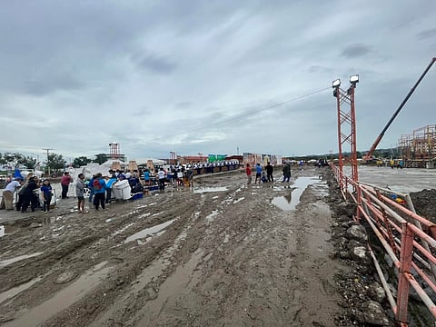 NOT READY. Members of the Talisay City contingent on Thursday, Jan. 12, 2023, hold rehearsals at the Sinulog 2023 Grand Parade venue at the South Road Properties (SRP) in Cebu City despite the mud on the unpaved grounds brought by rains earlier in the day. Talisay City Mayor Gerald Anthony Gullas Jr. appealed to Cebu City Mayor Michael Rama Thursday to transfer the holding of the event, set for Jan. 15, back to the Cebu City Sports Center due to concerns that using the new site at the SRP could pose a risk to their dancers and attendees. (Ivan Rey Tan)