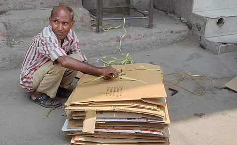 फकीरचंद गत्ते एकत्र करत हुए।