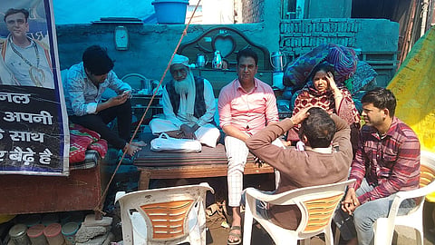 अपने टूटे मकान के बाहर परिवार के साथ बैठे रैट माइनर वकील हसन।