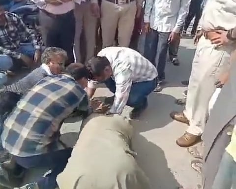 एक वीडियो में किसान बिजली अफसर के सामने दंडवत है.