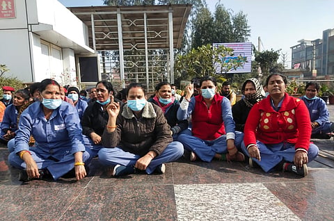Female sanitation workers at Burari Hospital stage a sit-in strike in protest.