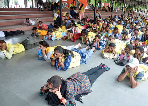People lie down with their ears plugged with fingers during the mock drill preparation at the Reserve Police Lines conducted by Civil defence ahead of the nationwide mock drill in Lucknow.