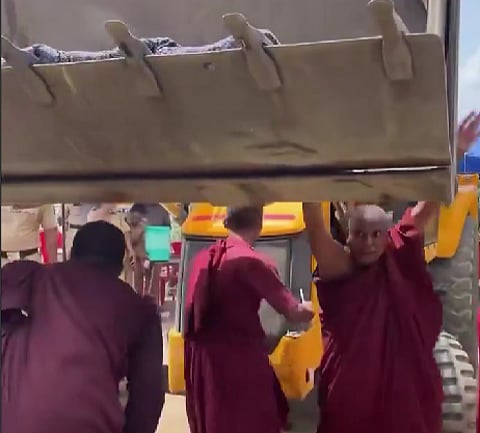 Videos circulating on social media show tense scenes of monks pleading with officials as machinery advanced.