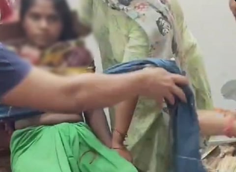 In the viral video, a woman is seen pressing a stick against the victim's neck in an apparent attempt to choke her while trying to force a confession.