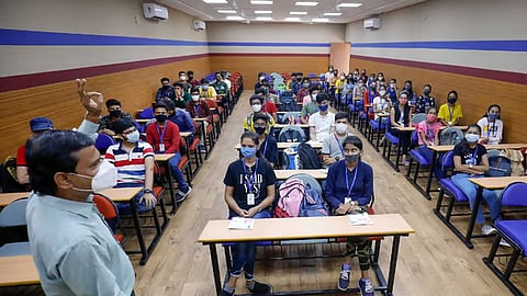 A professor and students in a college classroom