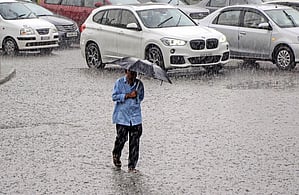 A representative image of a man walking with an umbrella while it rains