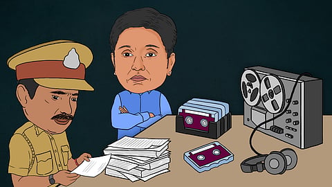 A cartoon shows a police officer sitting at a table examining documents. A character resembling Kiran Bedi stands with arms crossed, facing the scene. Tapes and headphones are on the table, with a stack of tapes nearby.