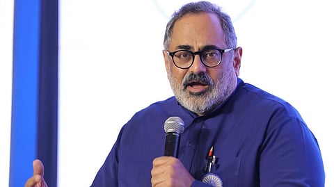 Rajeev Chandrasekhar in a blue shirt speaking via mic