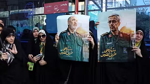 Iranians hold posters of late Islamic Revolutionary Guard Corps head Hossein Salami (left), and late Iranian Armed Forces Chief of Staff General Mohammad Bagheri (right), who were killed in Israeli airstrikes in recent days.