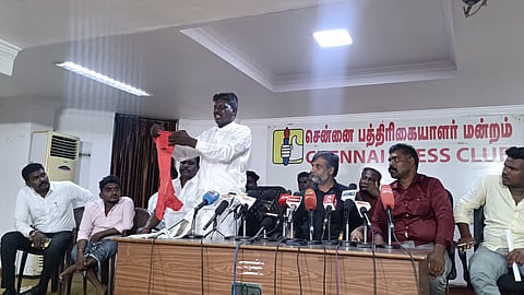 Rajendran displays clothes torn by the mob