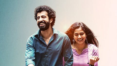 Roshan Mathew and Zarin Shihab in a still from 'Ithiri Neram'. Roshan in a blue shirt, holding Zarin's hand. She is wearing a lavender kurta and a floral dupatta