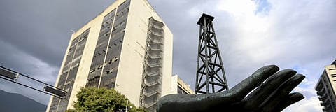 A sculpture of a hand holding an oil rig stands outside the headquarters of Venezuela’s national oil company.