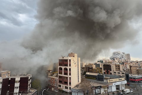 Plumes of smoke from two simultaneous strikes rise over Tehran, Iran, Monday, March 2, 2026.