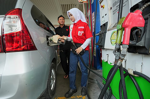 An employee fills up the fuel tank of a car at a gas station in Jakarta, Indonesia, Tuesday, March 3, 2026.