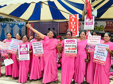 Rekha, an ASHA worker, with her fist raised during a protest.