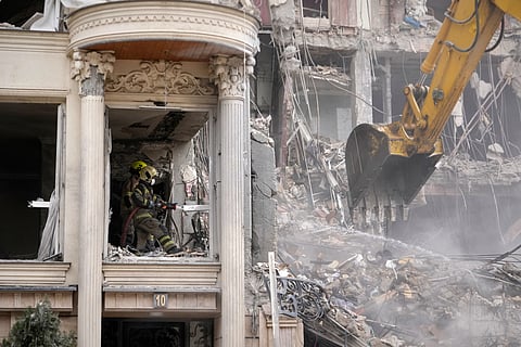 Rescue workers and first responders work at a residential building hit in an earlier U.S.-Israeli strike in Tehran, Iran, Monday, March 23, 2026.