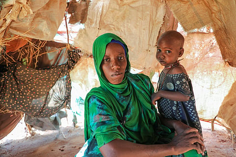 Nurto Madey, a mother displaced by drought, holds her daughter inside her makeshift hut at Ladan internally displaced persons (IDP) camp in Dolow, southern Somalia, Wednesday, March 25, 2026.