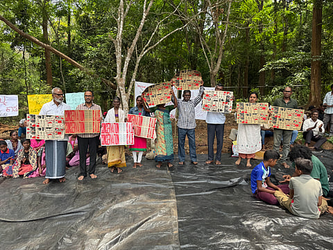Activists and adivasi community members hold post graphic posters depicting the history on conservation in Nagarahole with the tagline 'Conservation is a lie' during a three-day consultation between adivasis of Karnataka, Kerala and Tamil Nadu.