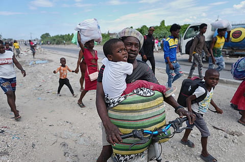 Residents flee their homes to escape clashes between armed gangs in Port-au-Prince, Haiti, Monday, May 11, 2026.