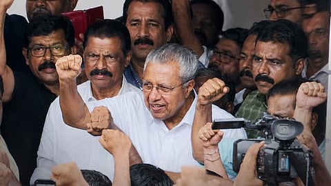PInarayi Vijayan greets CPI(M) workers protesting the ED raid at his residence with raised fist