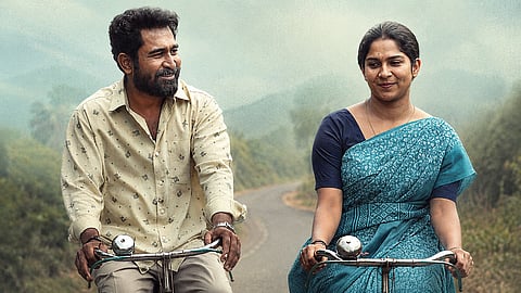 A still from Nooru Sami featuring Swasika and Vijay Antony riding bicycles on a rural road.