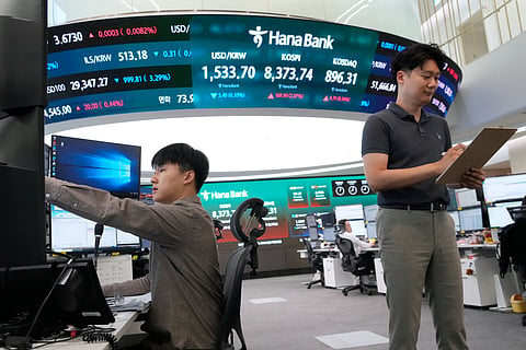 A currency trader watches monitors near a screen showing the Korea Composite Stock Price Index (KOSPI) and the foreign exchange rate between U.S. dollar and South Korean won at the foreign exchange dealing room of the Hana Bank headquarters in Seoul, South Korea, Wednesday, June 24, 2026.