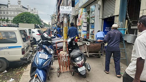 Vehicles parked on footpaths in KR Market.