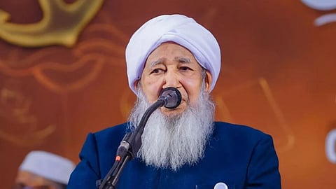Grand Mufti Kanthapuram Abubakr Ahmad wearing a blue suit and facing a mic