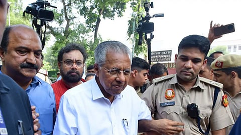 CPI(M) leader Pinarayi Vijayan's hand held by a police officer in Delhi. He is flanked by other CPI(M) leaders KN Balagopal and John Brittas
