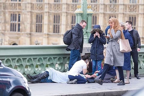 Photographer who captured woman in hijab 'walking past' at the London attack site defends her