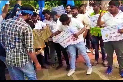 NSUI workers burning a pair of shorts at the residence of minister BC Nagesh