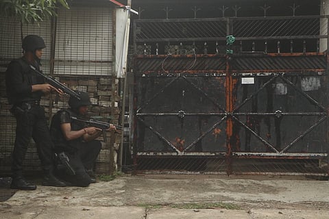 ATS officials standing outside a closed black gate