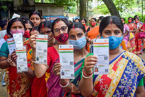 Women in a queue holding up their Aadhaar: No entry in electoral roll shall be deleted for non-submission of Aadhaar, says ECI