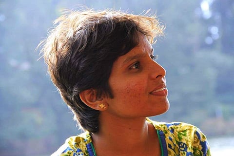 Picture of anti-caste activist Gowsalya in a yellow kurta, she is seen looking outside the frame