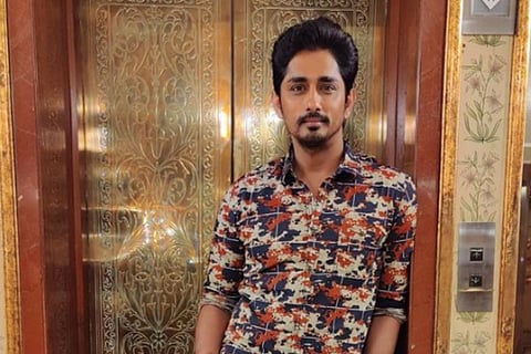 Actor Siddharth standing in front of a lift