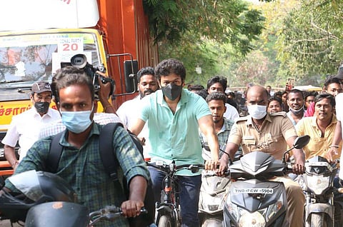 Actor Vijay seen wearing a green t-shirt and mask riding a red and black cycle to vote in Tamil Nadu elections 2021
