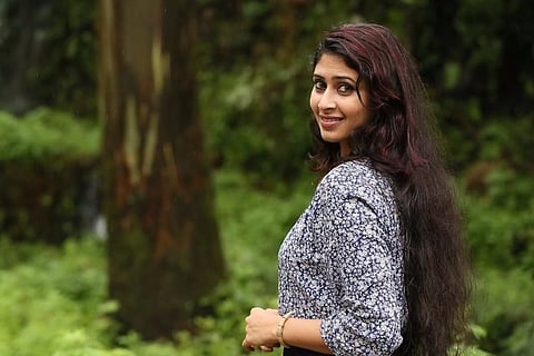 Aisha Sultana looking back and smiling into the camera