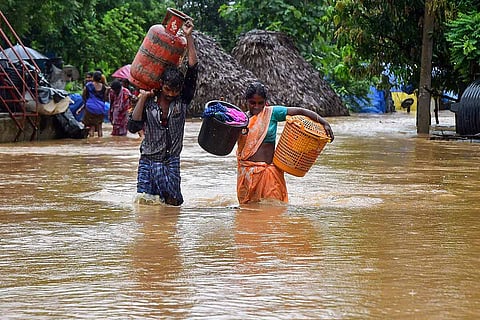 A couple wading through waist deep water in Andhra