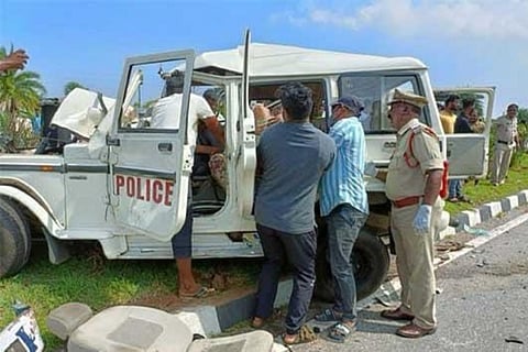 Police trying to bring out the dead bodies from the mangled police vehicle