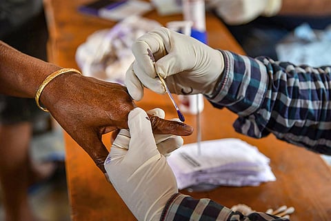 A person's finger being inked before voting