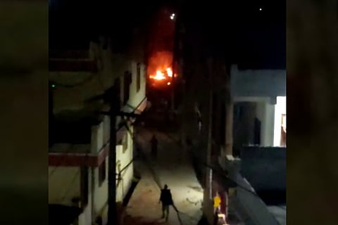 A policeman in Bhainsa walking towards a fire