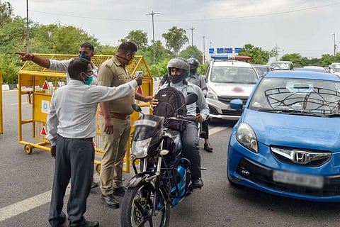 Police officials checking the temperature of a motorist at a checkpoint
