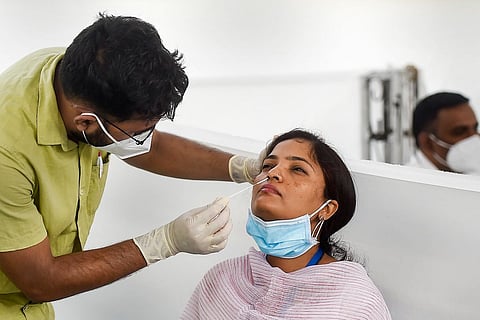 Health Professional collecting nasal swabs from a woman for Covid test