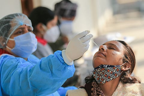 A health worker collecting swab sample from a woman for a COVID test